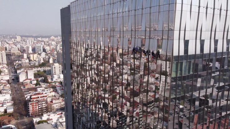 Incredibile e insolita vista aerea di lavavetri su un grattacielo di Buenos Aires.