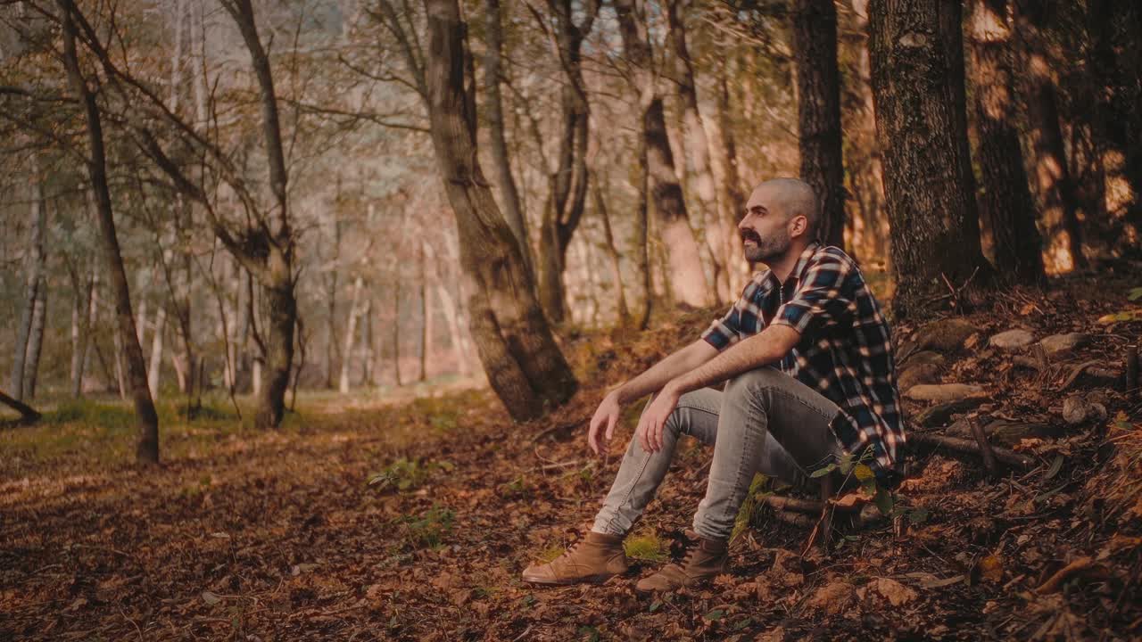Young man loves nature in autumn forest in Portugal. He feels warm and relaxed. Perfect clip for nature, travel, or self-development