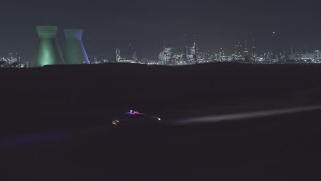 night aerial footage of a police car driving down a dark urban area