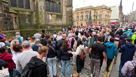 crowd gathers to watch street performers in edinburgh