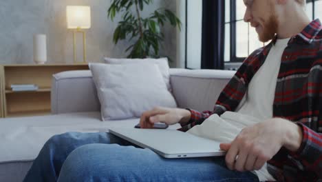 man using laptop and phone at home