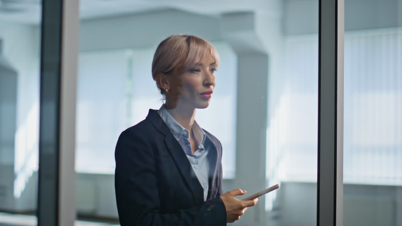 Corporate manager holding smartphone thinking inside office building closeup