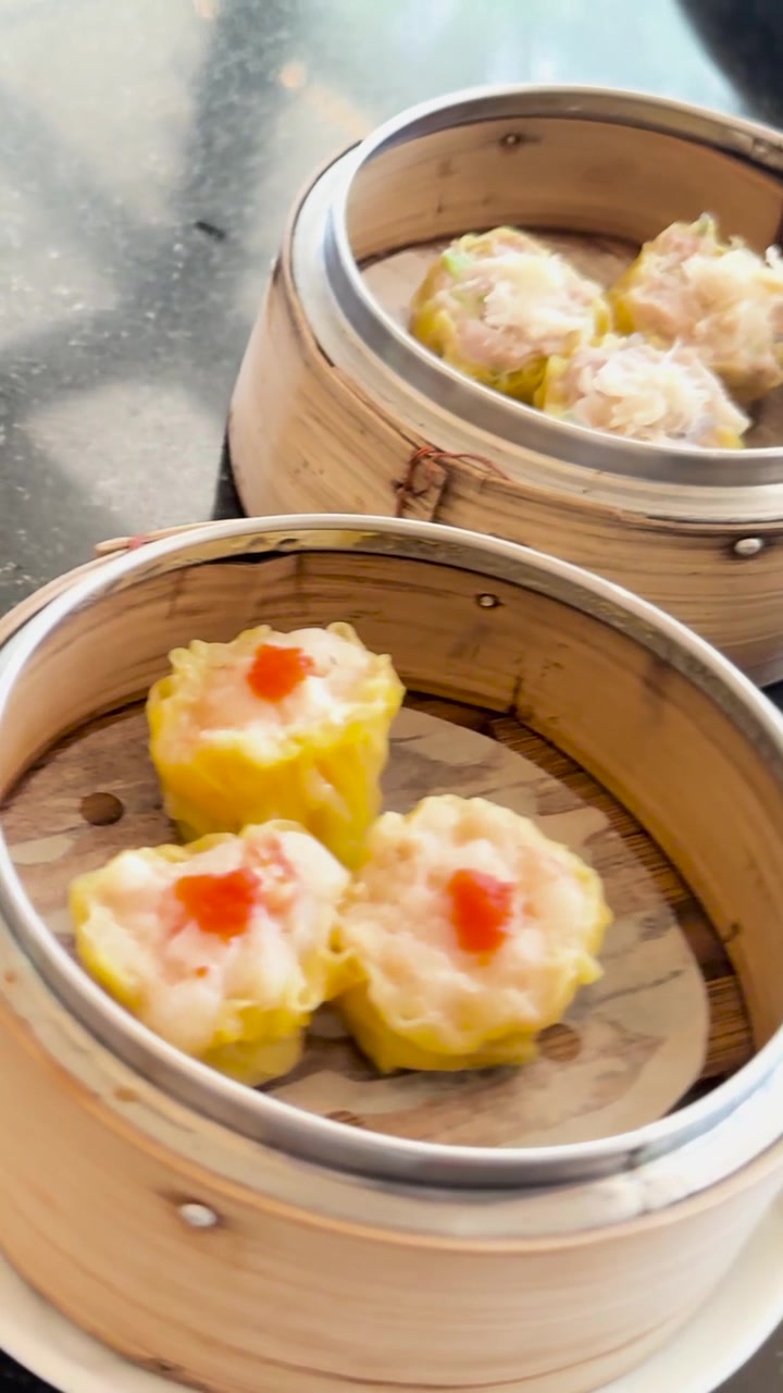 Hidangan dim sum disajikan di meja putar dengan saus