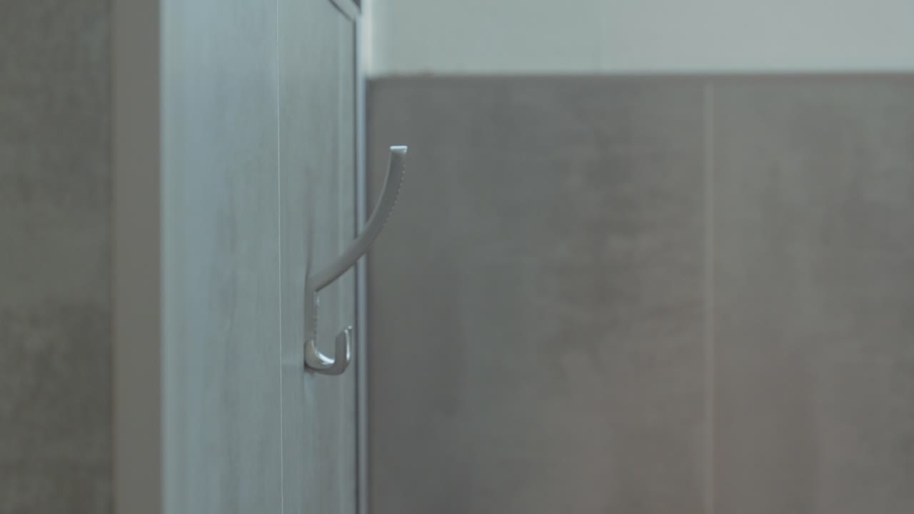 Primo piano di mani che appendono un accappatoio su un portasciugamani in una spa