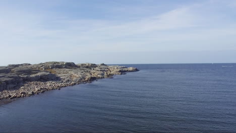 Drone-shot-of-rock-island-at-Gothenburg-Archipelago-during-clear-blue-sky