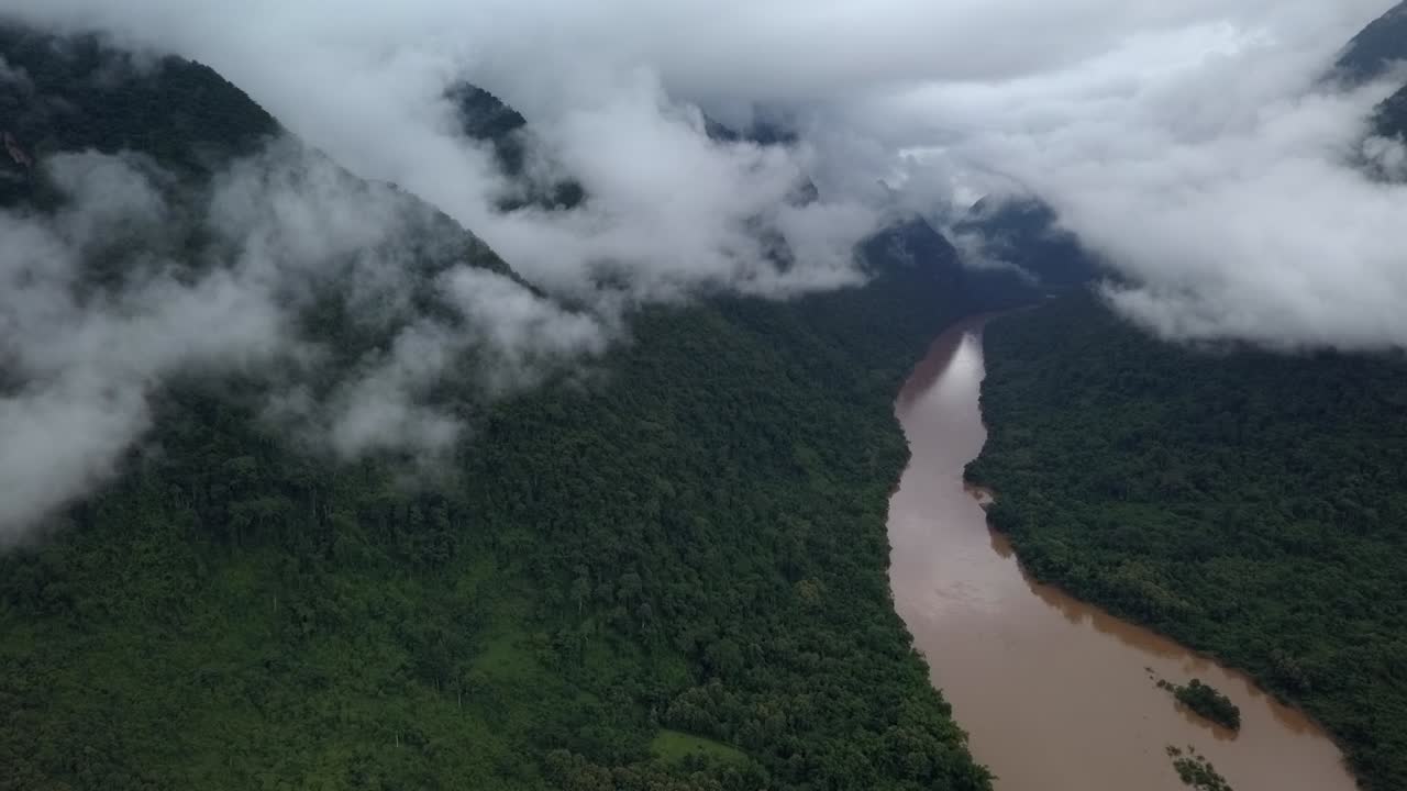 Ampia vista panoramica aerea di un fiume nella giungla circondato da splendide montagne nebbiose