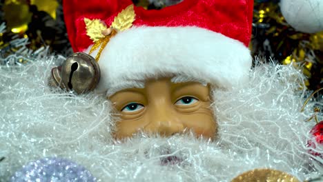 x-mas santa claus face in a red hat with bells, big white beard, christmas decoration, traditional holiday presents, new year decor, shiny colorful setup, creative close up tilt up shot, 4k video