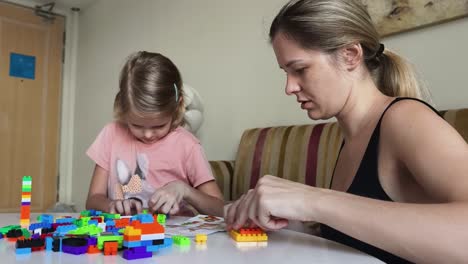 mother and daughter building with blocks