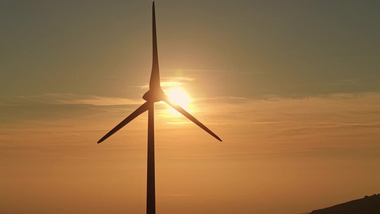 Große Windkraftanlage als Silhouette vor einem glühenden Sonnenuntergang