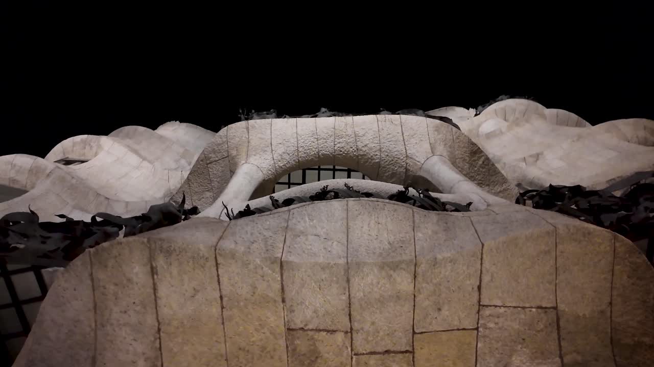 Nighttime ascending and contemplative discovery shot of the façade of Casa Milà, the iconic masterpiece by architect Antoni Gaudí, located in the Eixample district of Barcelona, Catalonia, Spain