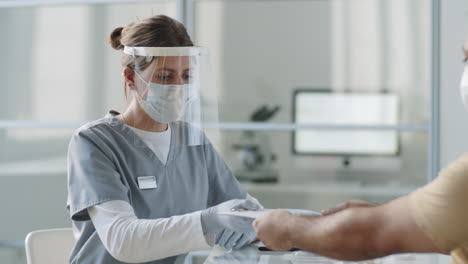 doctora en uniforme de protección que consulta a un paciente