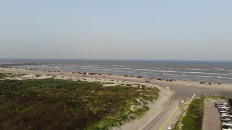 Panning-left-with-view-of-grasslands,-beach,-and-jetty