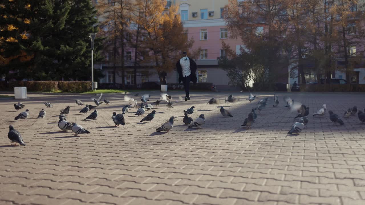 Man Running in City Park with Pigeons