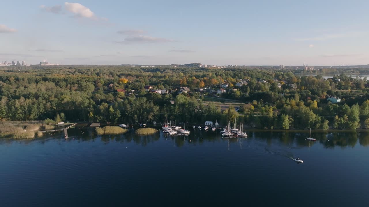 드론 촬영은 해안선과 함께 호수를 보여줍니다. 해안가에 배가 정박되어 있습니다.