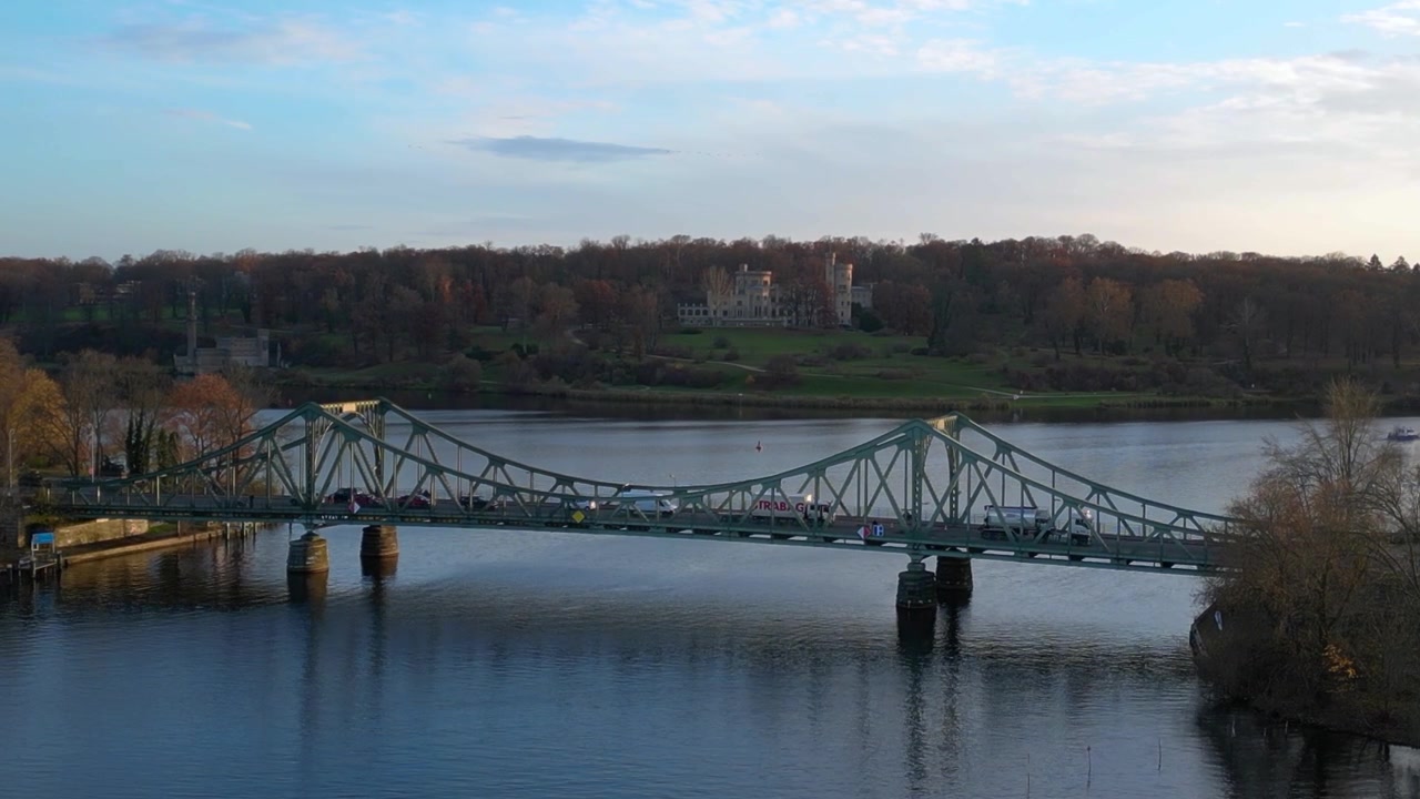 Ponte di Glienicke che attraversa il fiume Havel con il Castello di Babelsberg a Potsdam, Germania. Drammatica vista aerea da drone in hovering con treppiede statico.