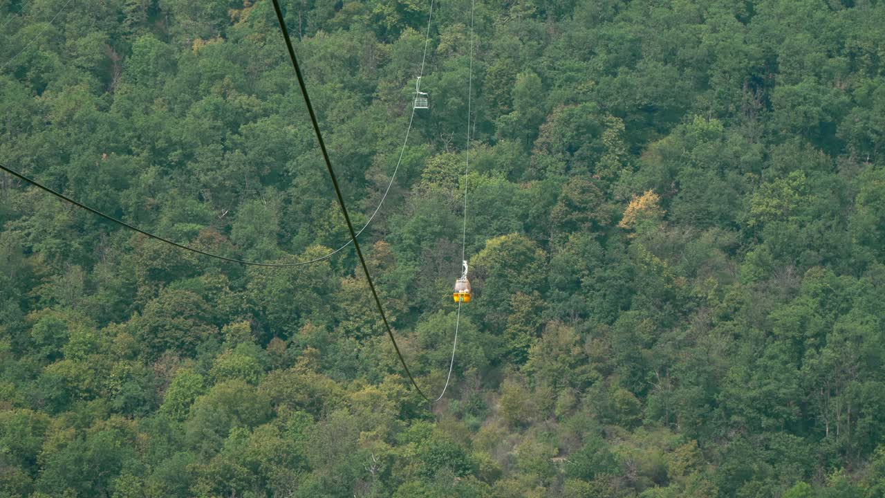 Gondola cable car gliding above lush green forests of the Zemplén Adventure Park in Sátoraljaújhely, Hungary, offering a scenic glimpse of the region's natural beauty and outdoor adventure