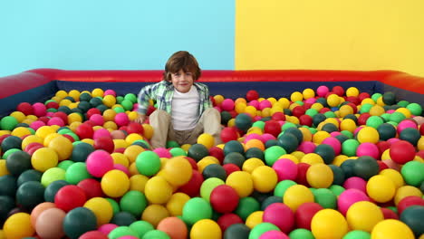 cute little boy playing in ball pool