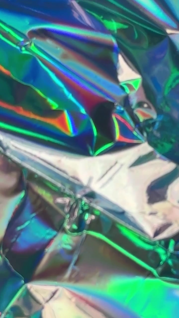 Abstrakter Hintergrund aus zerknitterter schillernder holografischer Folie