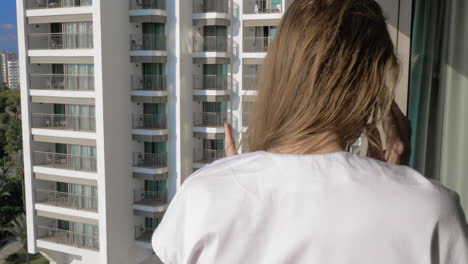 Fröhliche-Frau-Beim-Handygespräch-Auf-Dem-Balkon