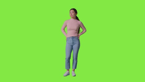 full length studio portrait of confident independent woman standing against green screen