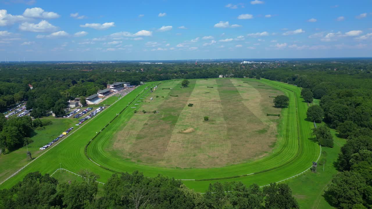 Horse gallop racecourse near a forest in Germany, parking lot visible. Majestic aerial view flight panorama orbit drone