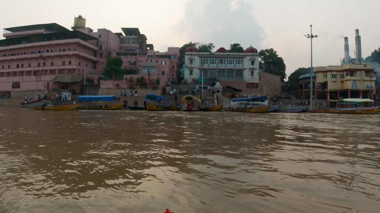 cinematográfico varanasi india ganges río canal crucero en barco estado del norte la gente se reúne en las escaleras cremación antigua ciudad santa provincia de ghat pradesh paisaje gris nublado fuego humo derecho movimiento
