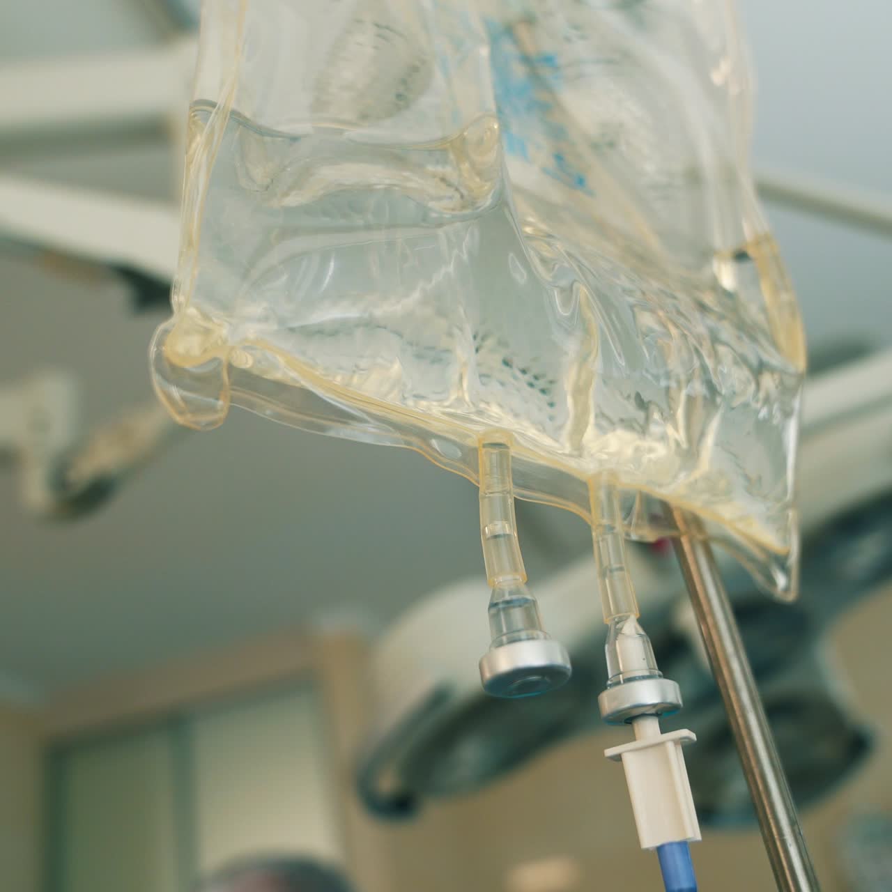 Drop counter transparent bag for medicine. Close up. Modern surgery room at backdrop in blur