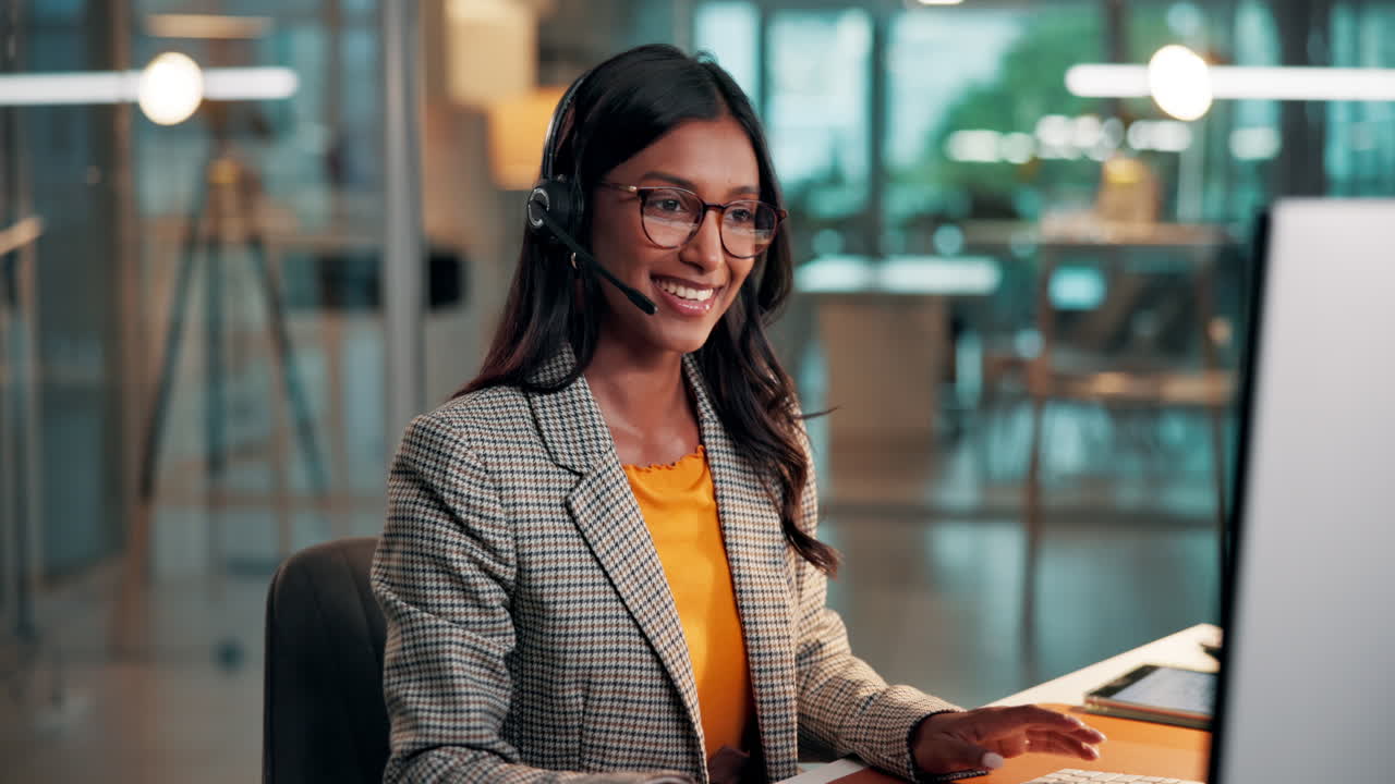 Mulher Profissional com Headset Falando e Digitando na Mesa do Escritório