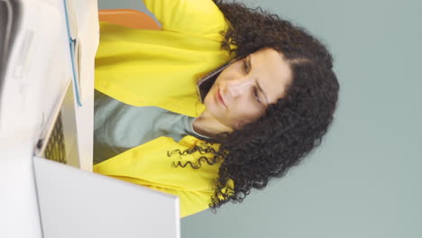 video vertical de una mujer joven trabajando duro en una computadora portátil.