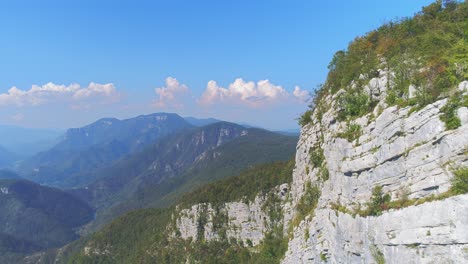 Dolly-Aéreo-Junto-A-Un-Muro-De-Piedra-En-El-Valle-De-Kostel-Con-Montañas-De-Fondo,-Eslovenia