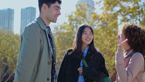 joyous friends chatting and laughing in the park after work