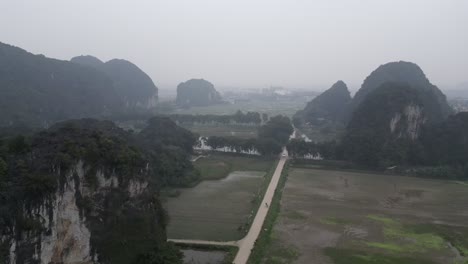 aerial-drone-shot-of-paths-going-through-the-valley-in-the-mountainous-region-of-Ninh-Ninh-in-Northern-Vietnam