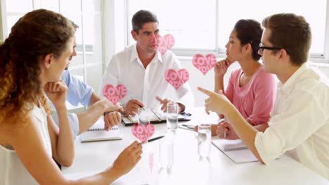 Animation of hearts floating over diverse businesspeople working in office