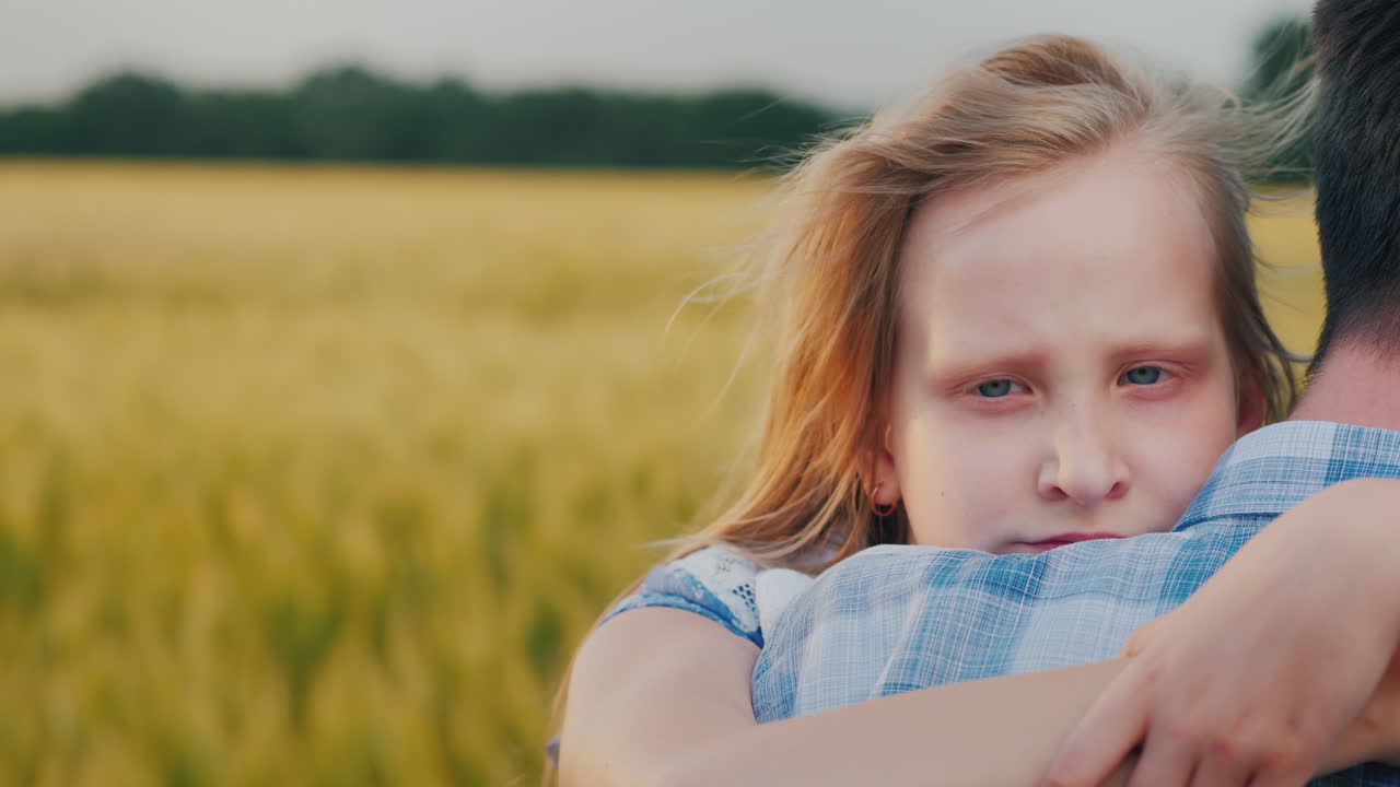 그 아이는 밀을 흔드는 강한 바람을 배경으로 아버지의 어깨에 달라붙는다