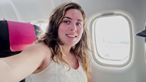 woman smiling at plane window, ready for vacation destination