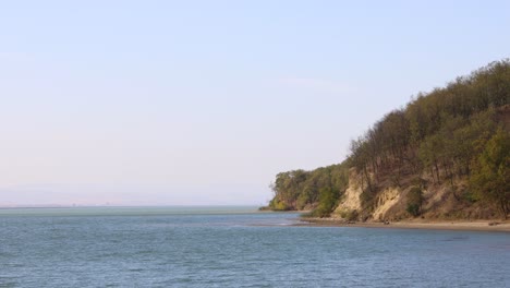 Hermoso-Paisaje-Del-Acantilado-Escarpado-En-La-Orilla-Del-Río-Tranquilo