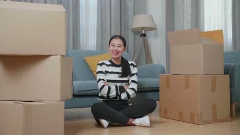 woman sitting among moving boxes in a living room