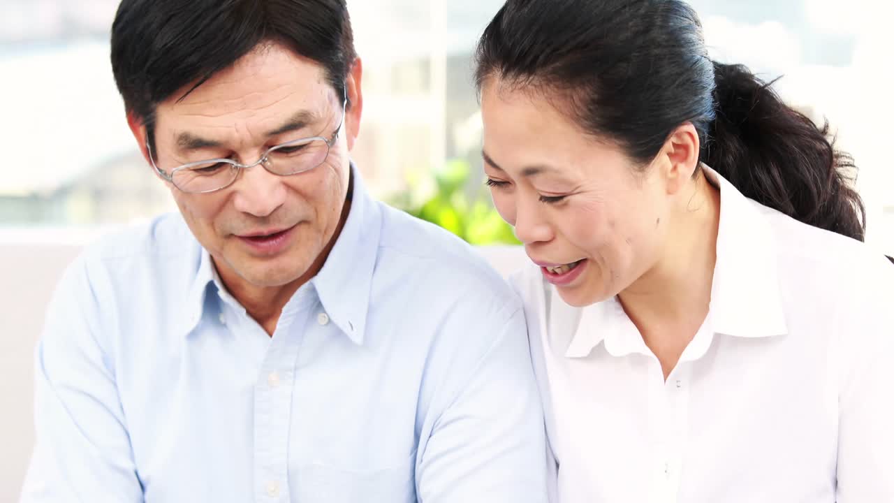 소파에서 스마트폰을 사용하는 성숙한 커플