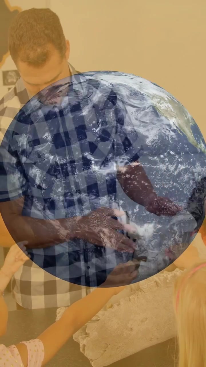 Vídeo vertical: Homem mostrando objeto perto da pia, crianças alcançando enquanto uma sobreposição da Terra cresce para aprendizado