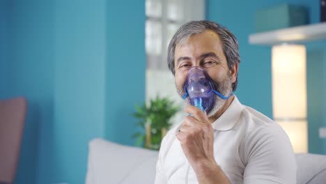 old man with copd takes off his ventilator and laughs at the camera.