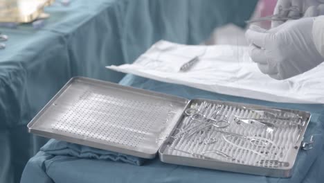 nurse preparing stainless steel wire on tweezers on little table