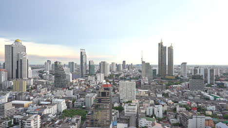 Slowly-pan-left---Bangkok-cityscape-and-skyline-from-skyscraper's-rooftop-on-a-cloudy-day,-bird's-eye-view-of-Bangkok-city-downtown