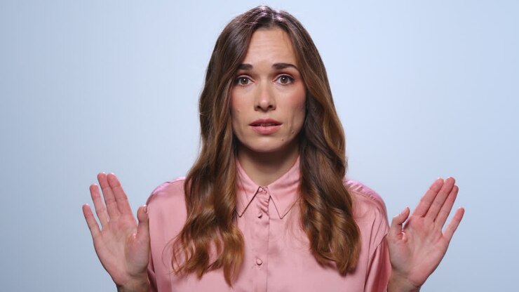 Businesswoman gesturing stop sign with hands. Girl showing negative gesture