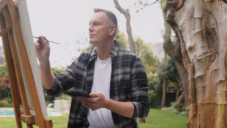 hombre pintando en lienzo en el jardín 4k