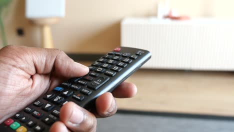 person holding a tv remote in a living room