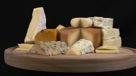 Food-presentation:-Cheese-platter-on-wooden-block-rotates-on-black