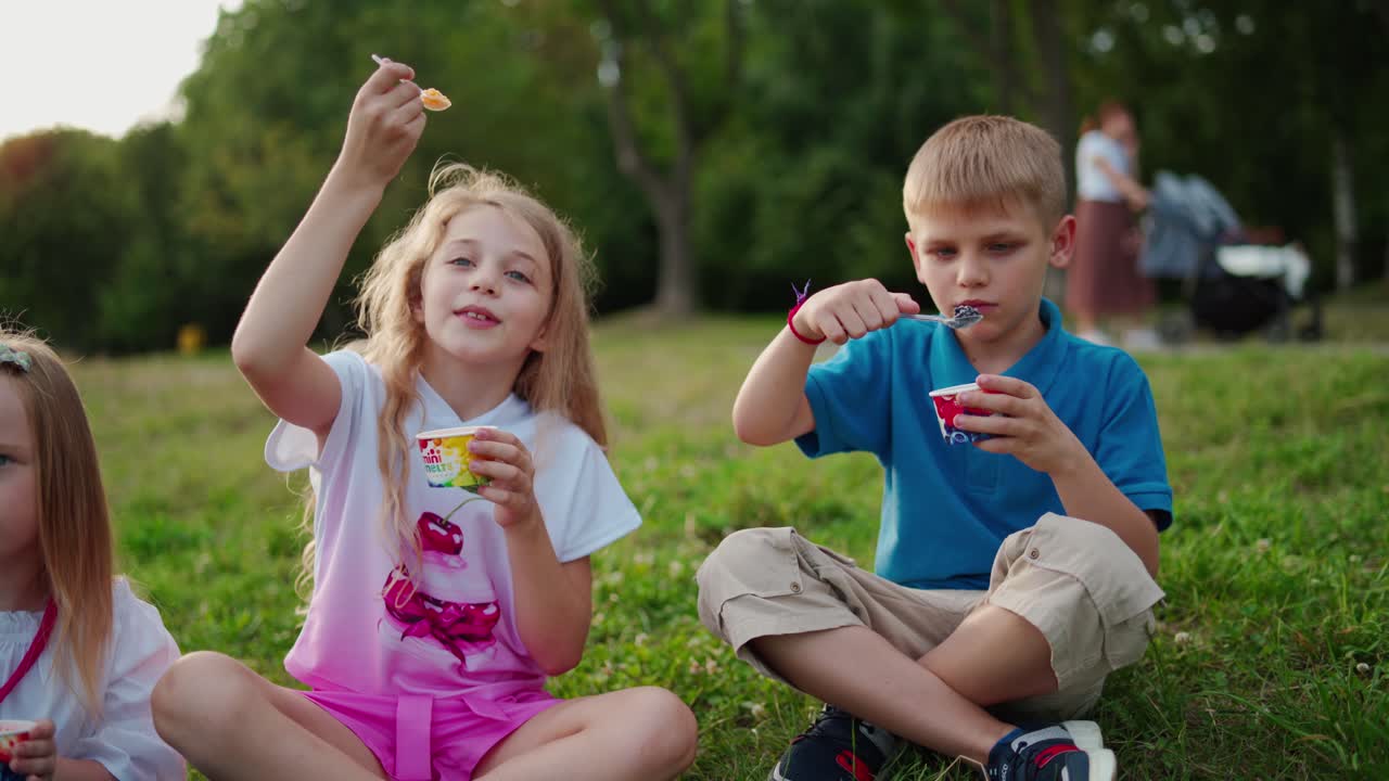 Group of kids in park. Happy children lying on green grass outdoors in park