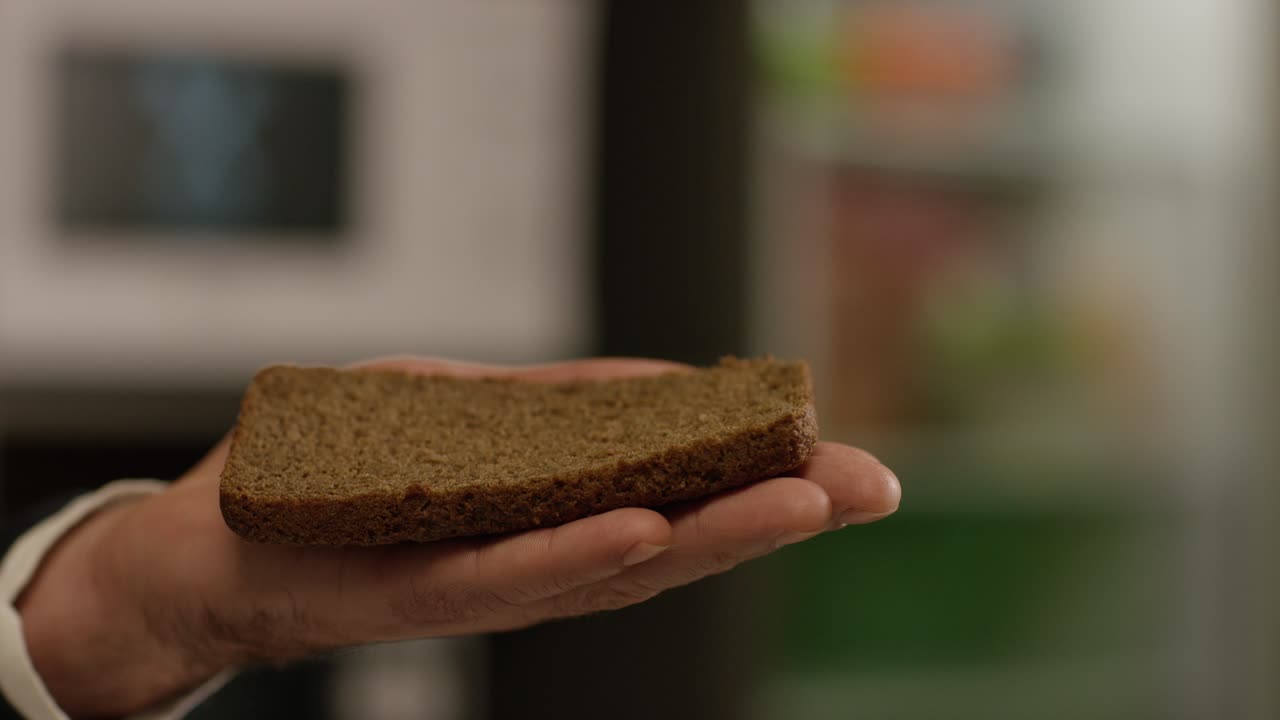 A slice of rye bread in a hand