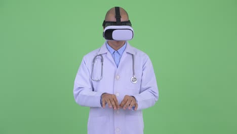 handsome bald multi ethnic man doctor with virtual reality headset