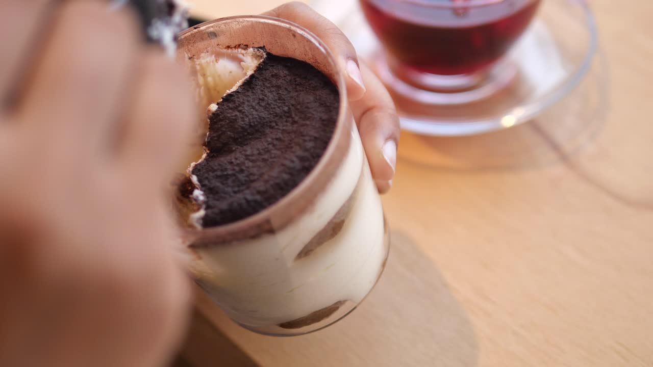 Woman enjoying tea and dessert at a cafe